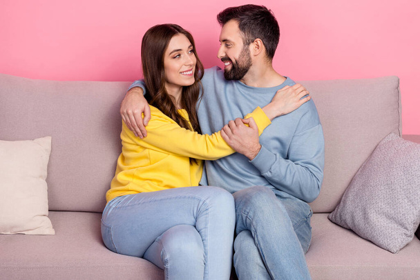 Portrait of attractive cheerful gentle couple bonding sitting on divan romance free time isolated over pink pastel color background - Foto, Imagen