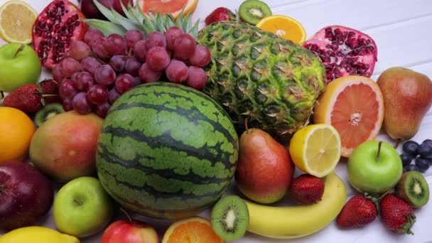 Různé čerstvé ovoce pro zdravé stravování. Meloun vodní, ananas, jablko, hruška, jahoda, kiwi, citron, pomeranč, hrozen, borůvka, granátové jablko, mango, banán. Dolly shot 4k - Záběry, video