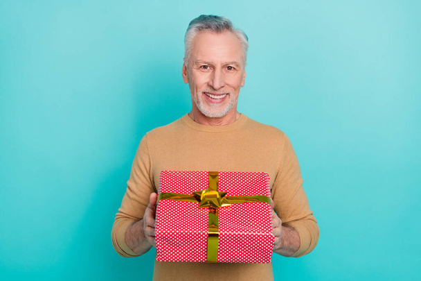 Portrait of handsome good mood cheerful male give you birthday present wrapper box isolated on teal color background - Photo, Image