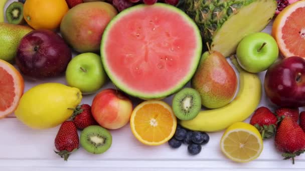 Různé čerstvé ovoce pro zdravé stravování. Meloun vodní, ananas, jablko, hruška, jahoda, kiwi, citron, pomeranč, hrozen, borůvka, granátové jablko, mango, banán. Dolly shot 4k - Záběry, video