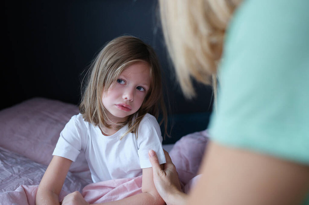 Αναστατωμένη μικρό κορίτσι επικοινωνεί με τη μαμά στο σπίτι - Φωτογραφία, εικόνα