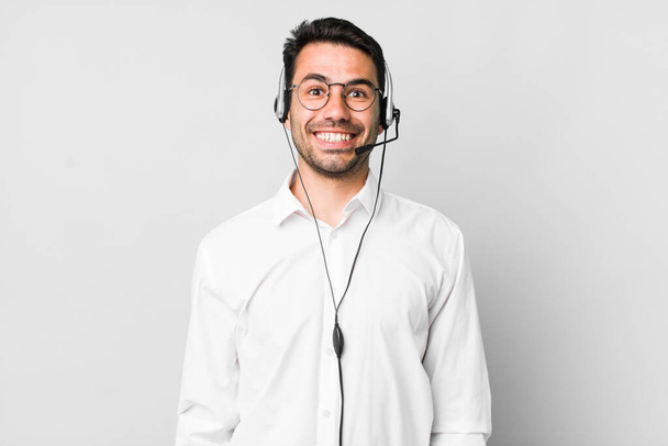 young adult hispanic man looking happy and pleasantly surprised. telemarketer concept - Photo, Image