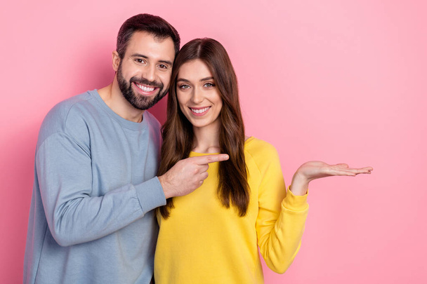 Portrait of beautiful handsome friends friendship holding copy space ad isolated over pink pastel color background - Φωτογραφία, εικόνα