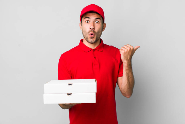 young adult hispanic man looking astonished in disbelief. pizza delivery concept - Foto, Bild