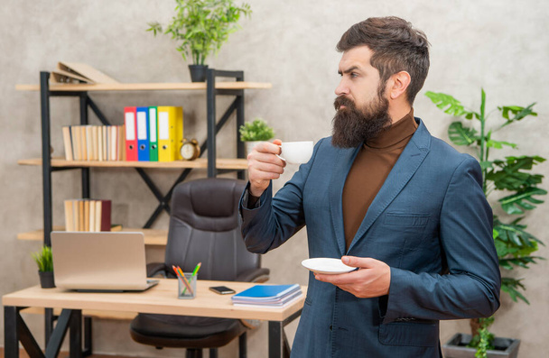 confident brutal ceo in businesslike suit has lunch break with coffee cup at the office, business - Φωτογραφία, εικόνα