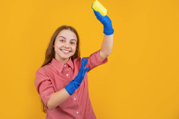 zadowolone dziecko w gumowych rękawiczkach z gąbką na żółtym tle - Zdjęcie, obraz