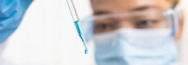 Scientists are carrying blue chemical test tubes to prepare for the determination of chemical composition and biological mass in a scientific laboratory, Scientists and research in the lab Concept. - Фото, зображення