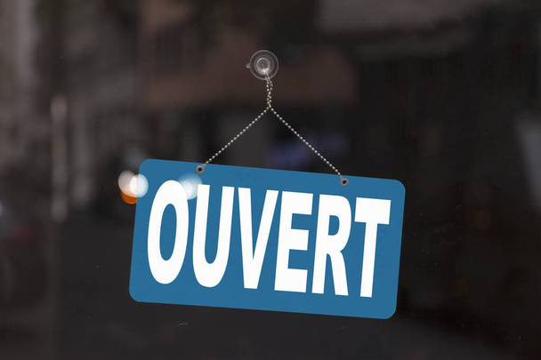 Bir dükkanın vitrinindeki mavi tabelaya yakın çekimde Fransızcada mesajı gösterir - İngilizce 'de Ouvert - Aç -. - Fotoğraf, Görsel
