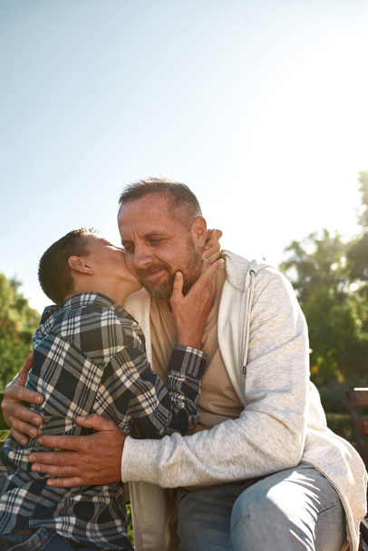 Boy with cerebral palsy kissing his happy father - Фото, зображення