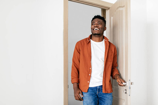Cheerful Black Guy Entering New Home Opening The Door - Foto, immagini