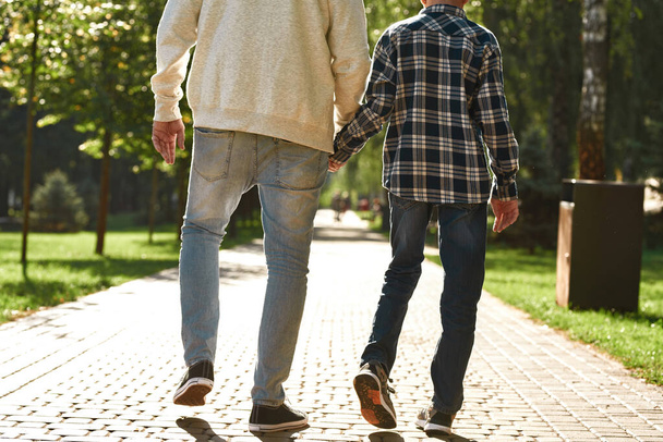 Cropped back of father and son walking on pavement - Fotografie, Obrázek