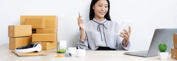 Jóvenes mujeres asiáticas están vendiendo productos en línea y están utilizando teléfonos móviles para chatear con los clientes para confirmar pedidos, la venta de productos en línea o haciendo trabajo independiente en el concepto de casa. - Foto, imagen