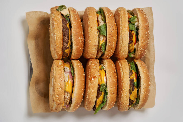 Six burgers on craft recyclable paper in tray - Fotó, kép