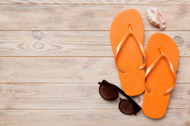 Summer travel concept. Flip flops, sunglasses and starfish on white. Top view on colored background. - Photo, image