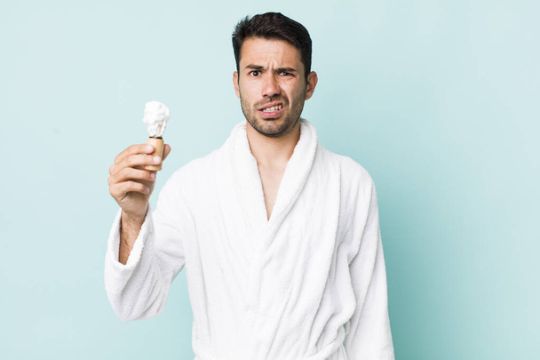 young adult hispanic man feeling puzzled and confused. shaving concept - Φωτογραφία, εικόνα