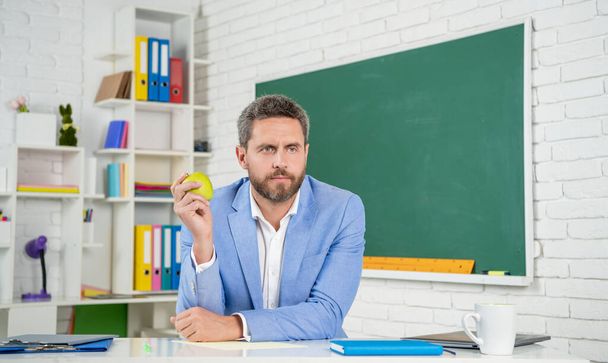 serious school tutor in classroom at blackboard - Фото, зображення