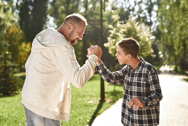 Father and son with cerebral palsy shaking hands - Photo, image