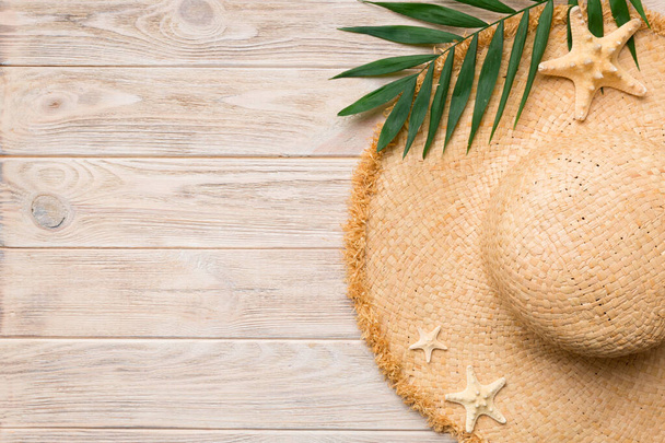 Summer holidays. Summer concept with straw hat and tropical leaf. Flat lay, top view, copy space. - 写真・画像