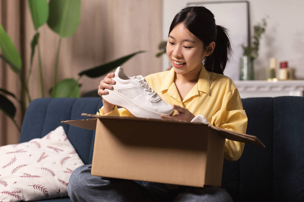 Happy Asian woman unpacking parcel after online shopping - Foto, Imagem
