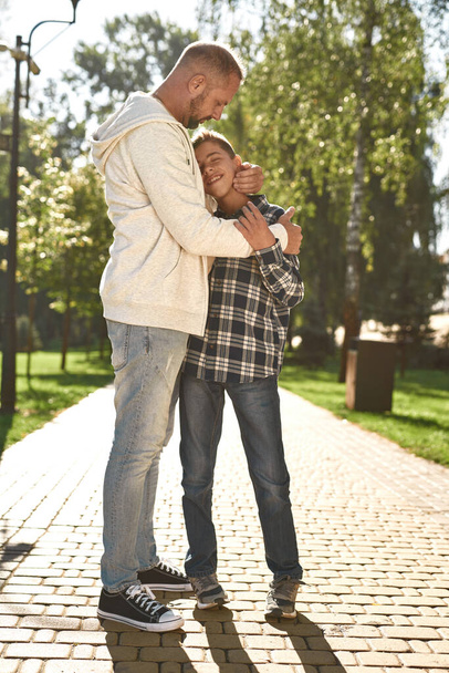 Father hugging enjoying son with cerebral palsy - Fotoğraf, Görsel