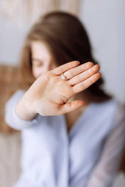 young woman shows a ring with diamond. The girl shows an engagement ring on her finger. she said yes. selective focus on hand - Foto, afbeelding