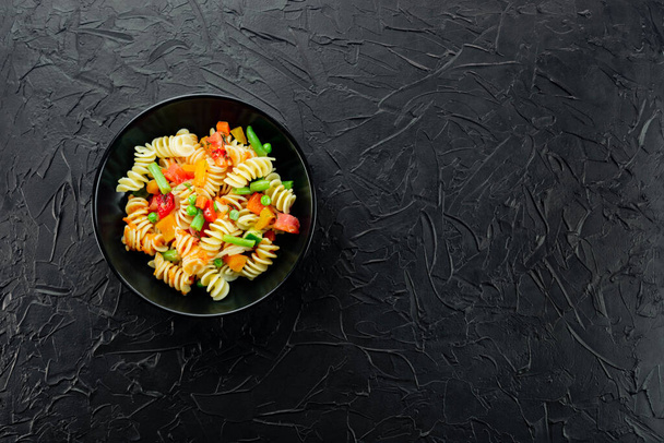 Italské těstoviny se zeleninou a koření na tmavém pozadí. - Fotografie, Obrázek