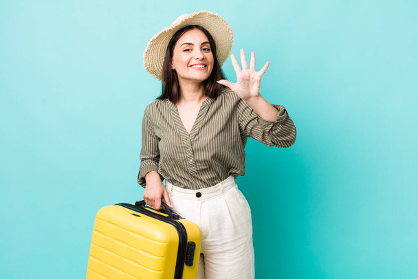 young pretty woman smiling and looking friendly, showing number five. travel concept - Foto, Imagen