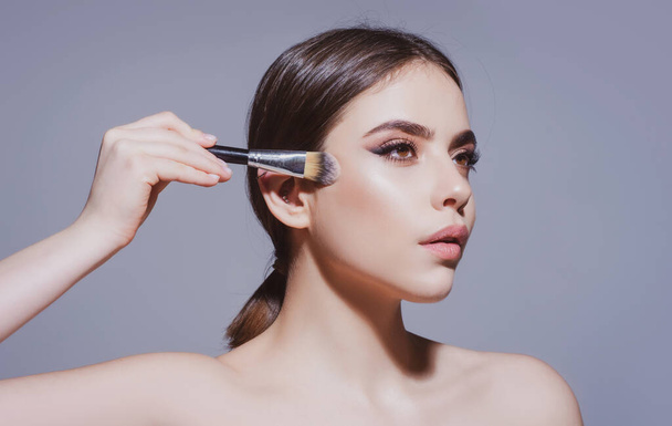 Beauty Makeup and cosmetics. Woman with makeup brush. Visage. Skincare treatments. - 写真・画像