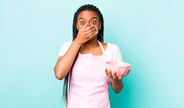 young adult black woman covering mouth with hands with a shocked. empty bowl concept - Foto, imagen