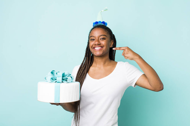 young adult black woman smiling confidently pointing to own broad smile. birthday concept - Foto, Imagem