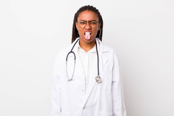 young adult black woman feeling disgusted and irritated and tongue out. physician concept - Foto, Bild