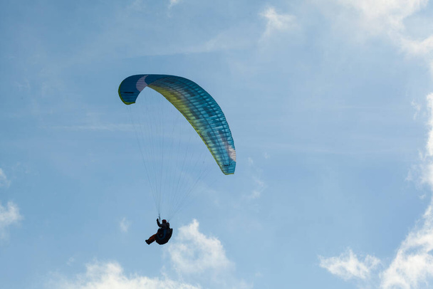 Parapente volando sobre las nubes en el día de verano
 - Foto, imagen