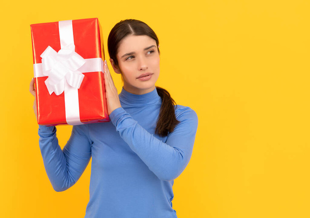 seasonal sales. curious girl with box on yellow background. boxing day. present and gifts buy. - Foto, Bild