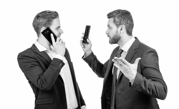 співробітник показує смартфон босові. чоловіки партнери жестикулюють на ділових переговорах
. - Фото, зображення