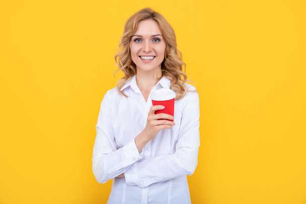 mujer rubia feliz con taza de café de la mañana sobre fondo amarillo - Foto, imagen