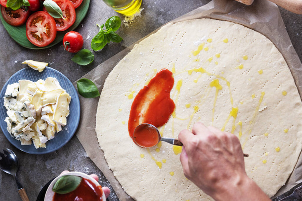 Closeup hand of chef baker making pizza at kitchen. - Foto, Bild