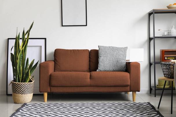 Интерьер светлой гостиной с коричневым диваном - Фото, изображение