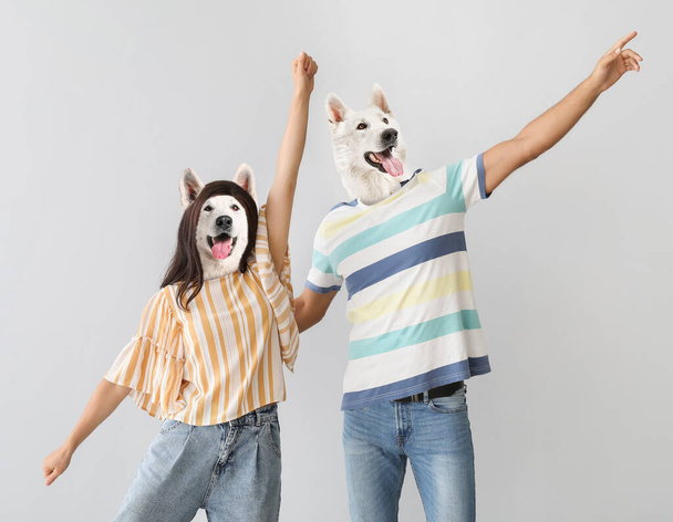 Funny dancing dogs with human bodies on grey background - Photo, Image