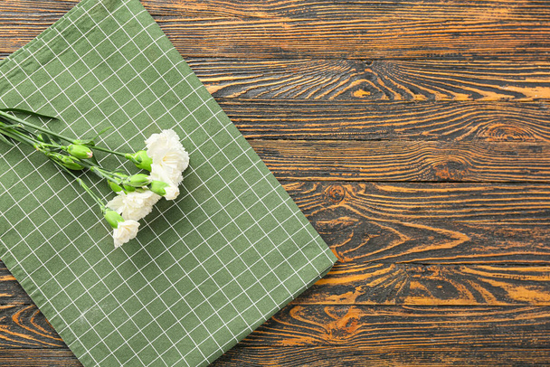 New napkin for picnic and carnation flowers on wooden background - Photo, image
