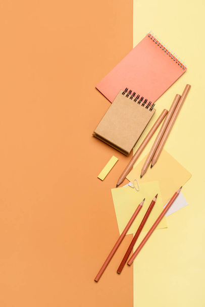 Notebooks with pencils on color background - Fotoğraf, Görsel