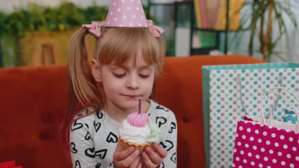 Pienet lapset tyttö istuu sohvalla paljon lahjoja juhlii syntymäpäivää - Materiaali, video