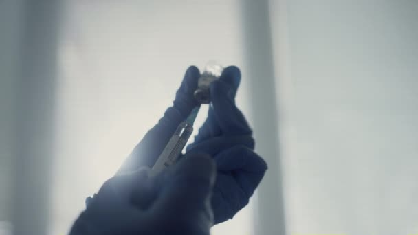 Médico manos llenando jeringa con medicamentos antivirales sosteniendo el vial de cerca. - Metraje, vídeo