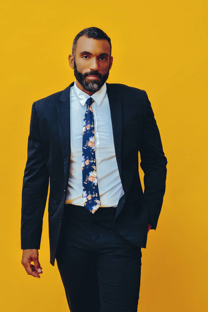 portrait of handsome bearded man in suit and tie, isolated on yellow background - Zdjęcie, obraz