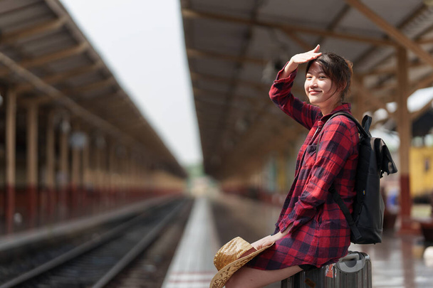 Young traveler woman planning trip at train station. Summer and travel lifestyle concept. - Foto, Imagen
