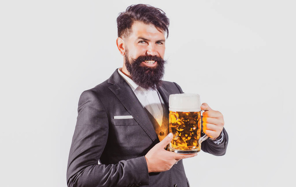 Красивий чоловік в чорному костюмі п'є пиво на білому тлі
. - Фото, зображення