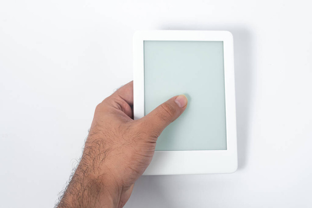 Ebook reader πάνω από απομονωμένο λευκό φόντο - που κρατιέται από ένα αρσενικό χέρι - Φωτογραφία, εικόνα
