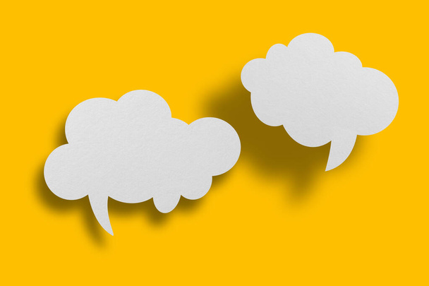 White paper in speech bubble shape set against yellow background.Communication bubbles. - Foto, afbeelding