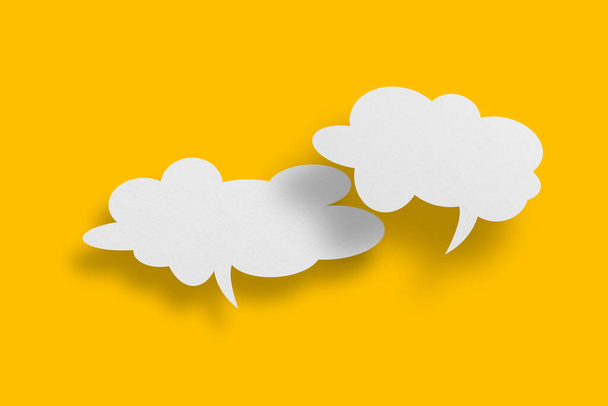 White paper in speech bubble shape set against yellow background.Communication bubbles. - Photo, Image