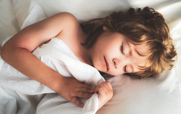 Crianças adormecidas jaz na cama com os olhos fechados. - Foto, Imagem