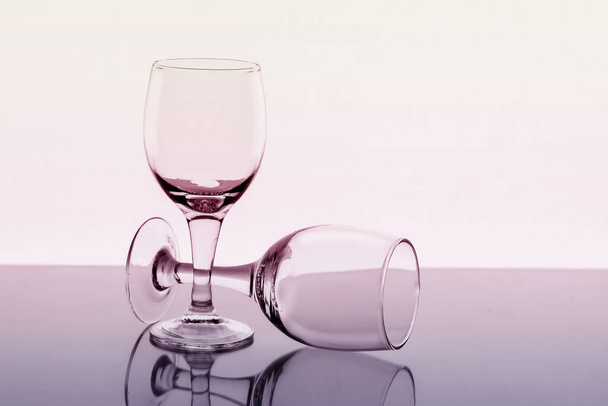 Two empty wine glasses with reflection on background, toned. - Φωτογραφία, εικόνα